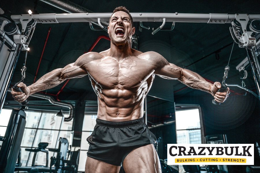 Physically fit man performing arm and chest exercises at the gym, engaged in intense resistance workout next to a CrazyBulk logo. Detailed view of muscular contraction. Emphasizing SARM alternatives benefits.