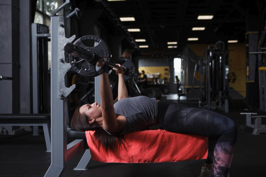 Woman performing bench presses at the gym