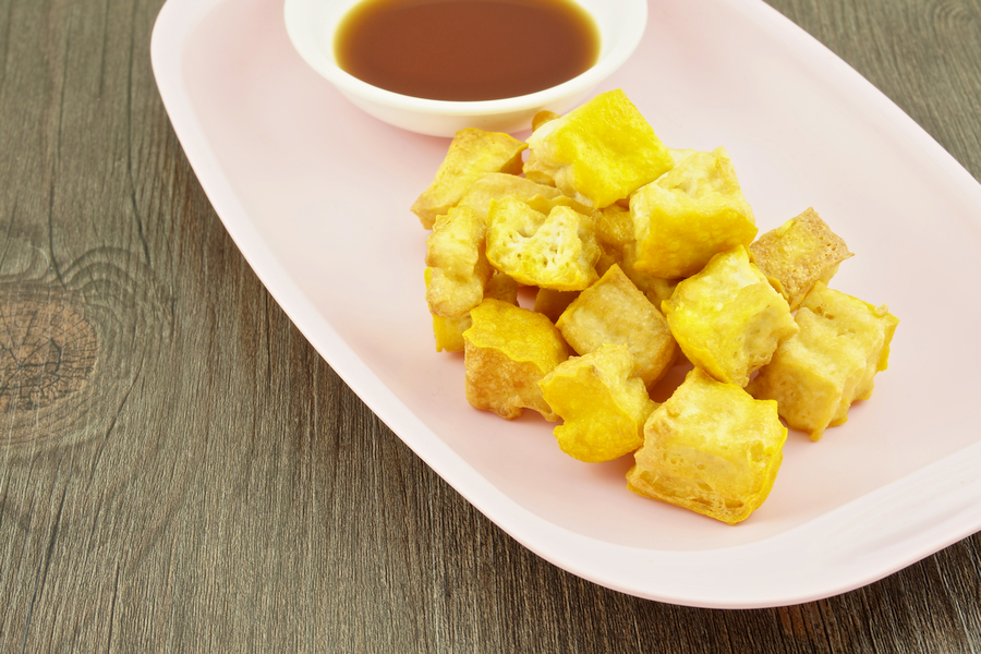 A plate of fried tofu with soy sauce
