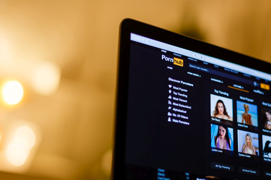 Photo of a laptop screen with a porn site homepage displayed.